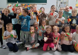 Dzieci pokazują zrobione przez siebie jabłuszka
